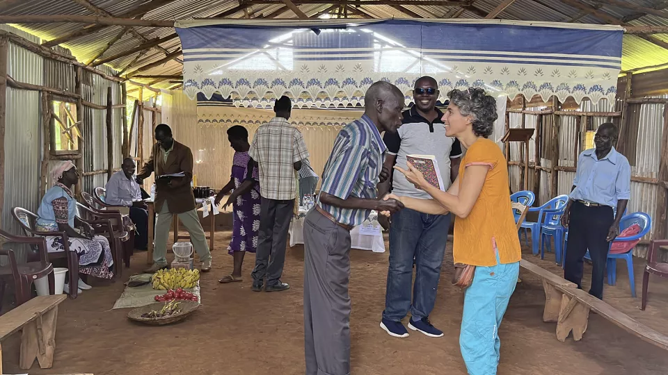 A man and a woman discussion. Other people in the background. Photo