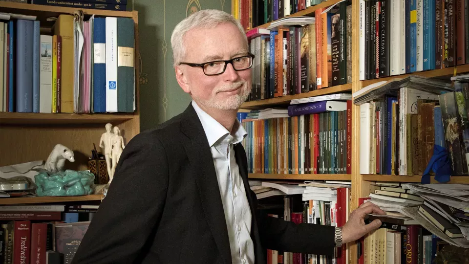 A man at a bookcase. Photo
