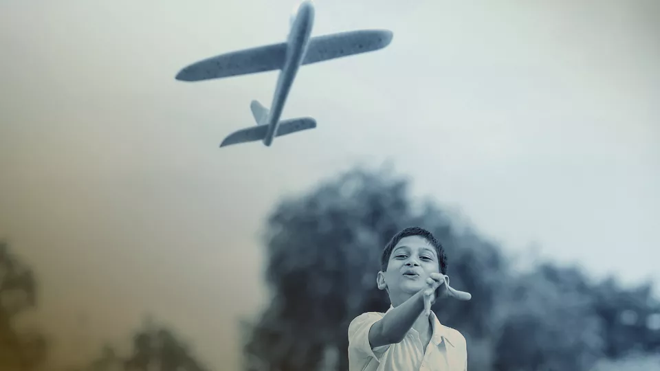 Photo of a boy playing with an airplane toy