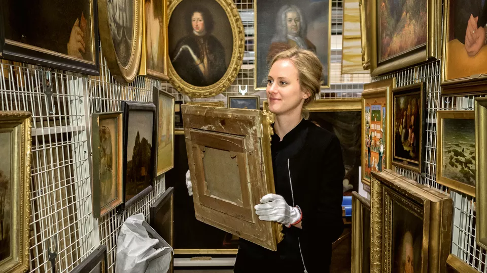 Woman surrounded by old paintings.