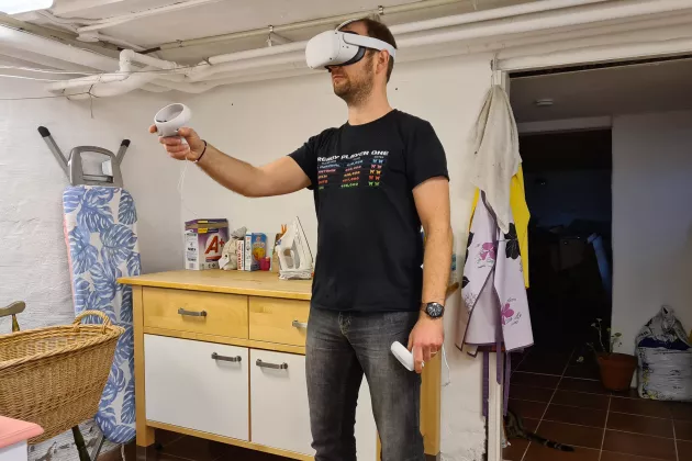 Man standing with VR-equipment in a laundry room.