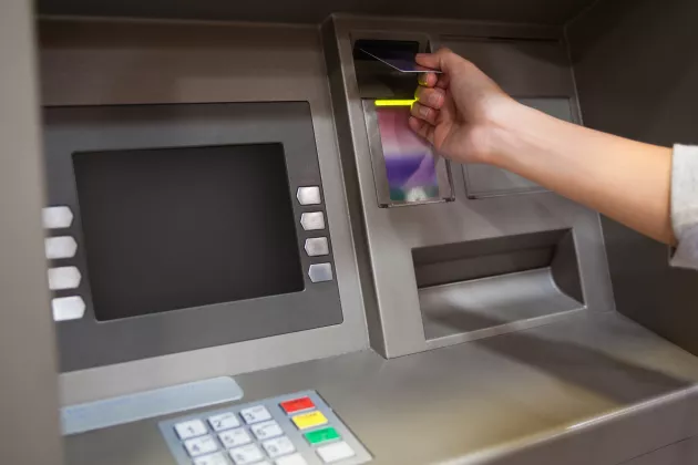Hand inserting a credit card in a ATM-Machine.