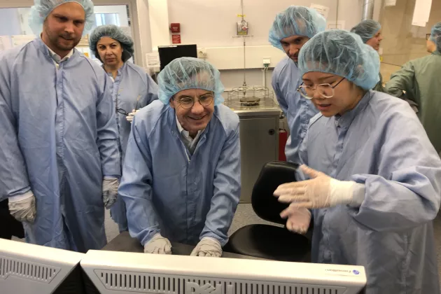 The Prime minister and other in lab clothes in a lab environment.