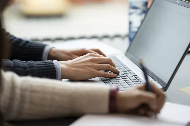 two person's hands on a laptop.