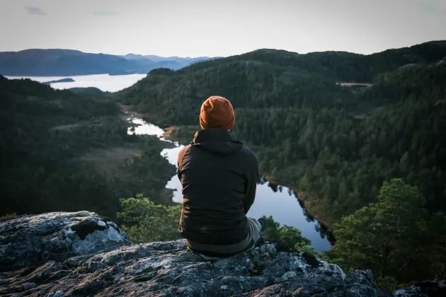 A person looking out over the mountains and water. A photo