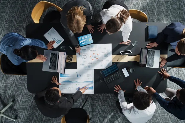 People sitting  around a desk discussing. Stockphoto.