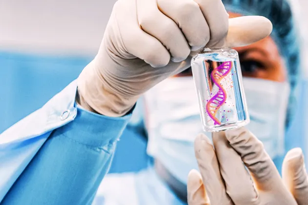 A women in lab clothes holding a test tube.