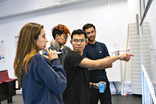 Students talking in front of an white board.
