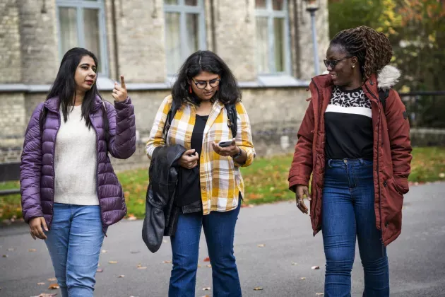 Three women walking at campus.