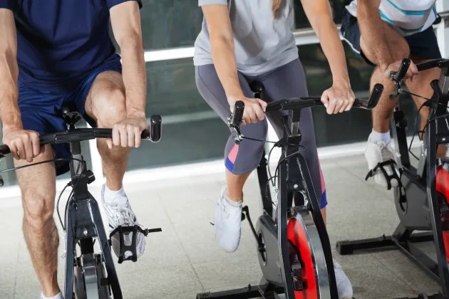 Low section of people on exercise bikes