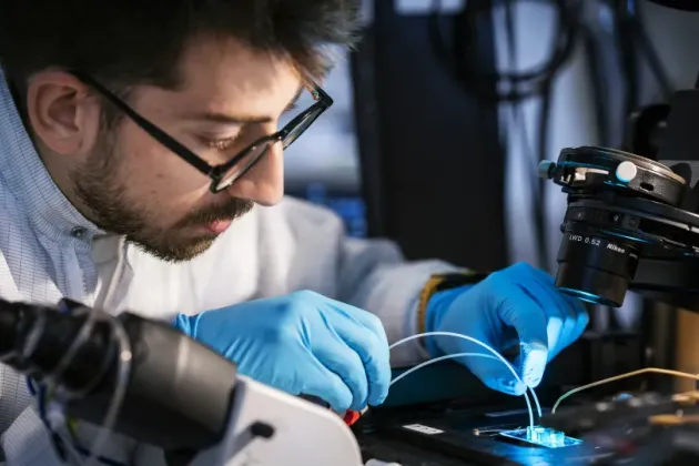a man looking in a microscope.