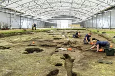 Archaeologists digging in a huge tent. Photo