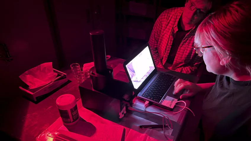 Photo of two researchers inside a mobile luminescence laboratory.