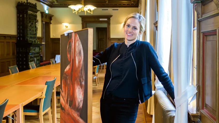 Annie Lindberg moving a painting in the Old Bishop’s House.