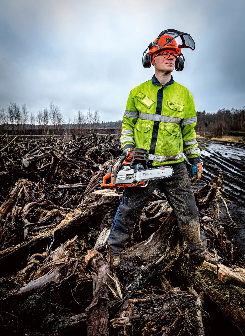 Man in mud with chainsaw